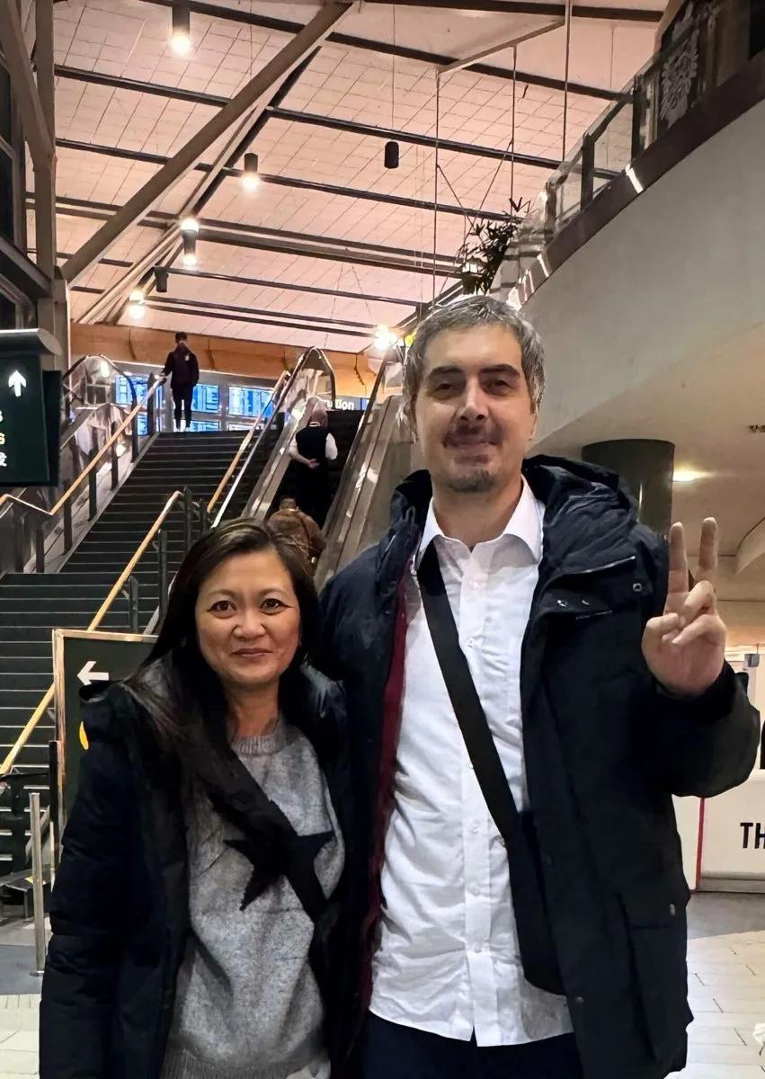 Mauro standing with another person in a transit terminal