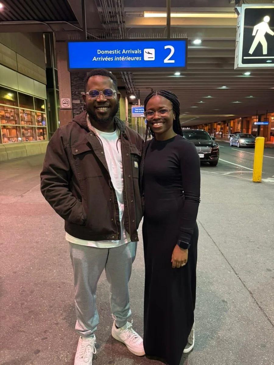 Tobi standing with another person outside an airport arrivals area in Calgary